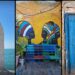 The image consists of 3 photos side by side: an old wooden door, a wall painting of 2 women and a structure similar to an old window with the sea behind it,